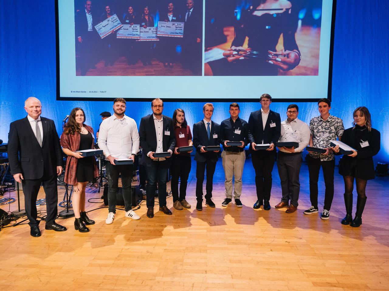 Several people standing on a stage with an award in their hands