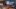 heiCONF-Logo vor einem PC-Arbeitsplatz mit laufender Videokonferenz